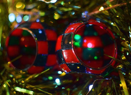 Close-up of red and green checkered Christmas ornaments on a blurred festive background