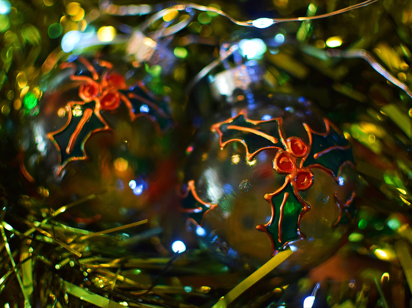 Decorative glass baubles with holly design on a festive background